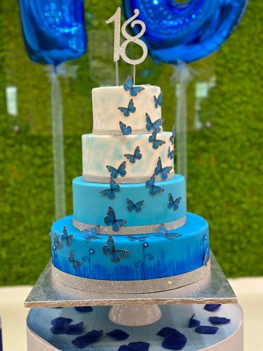 Allestimento 18 Anni Elegante Blu e Argento con Balloon Columns e Backdrop Verde – Decorazione Luxury con Farfalle